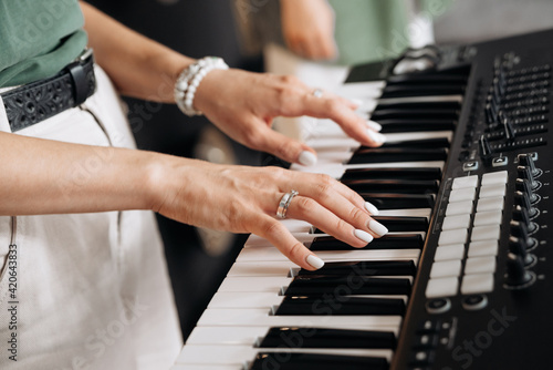 Crop musician playing electric piano in studio photo