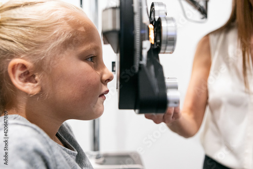 Eyewear: Tech Checks Prescription Of Young Girl With Phoropter photo