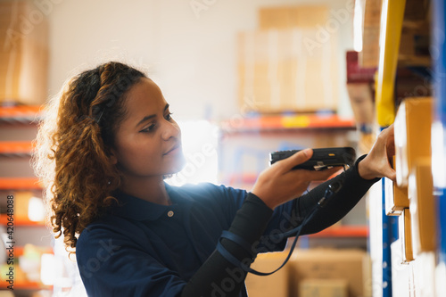 Portrait of African American worker in warehouse, International export business concept, occupation industrial in factory storage, warehouse worker using bar code scanner to analyze newly arrived good