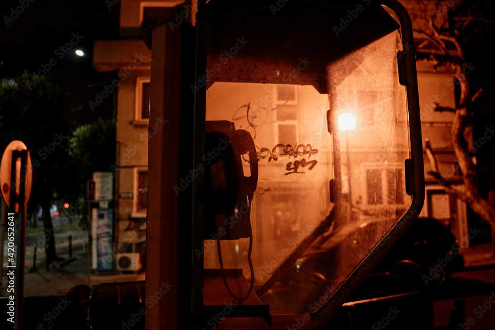 Old phone booth in dark street at night
