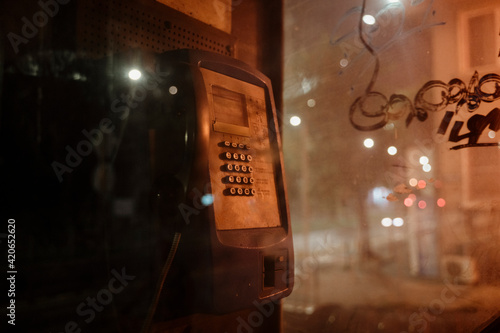 Old phone booth in dark street at night photo