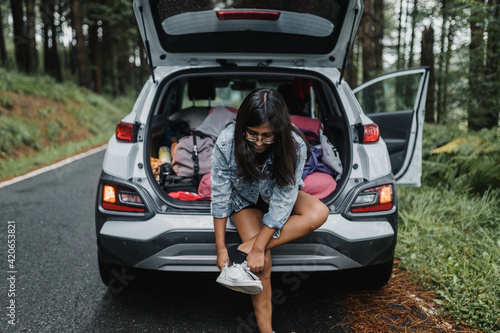 Woman tying her shoes in the car photo