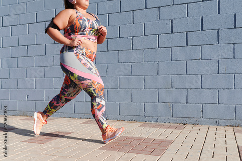 Full-figured woman running on a sidewalk