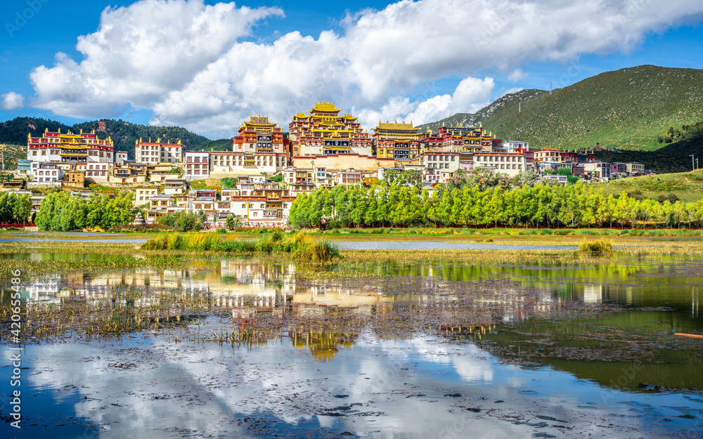 Ganden Sumtseling monastery scenic panorama with lake and water reflection Shangri-La Yunnan China