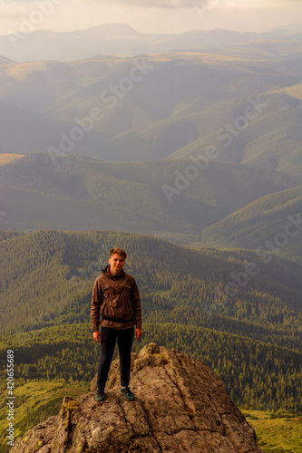 Young boy, tourist, portrait photos of a guy in the Carpathian mountains, picturesque and impressive Ukrainian Carpathians, view from the mountain Pip Ivan Chornohirsky.