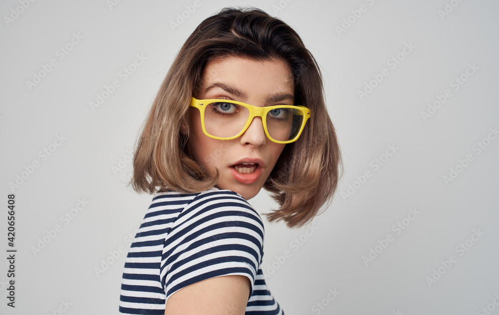 pretty woman in yellow glasses striped t-shirt gray background model pretty woman in yellow glasses striped t-shirt gray background model