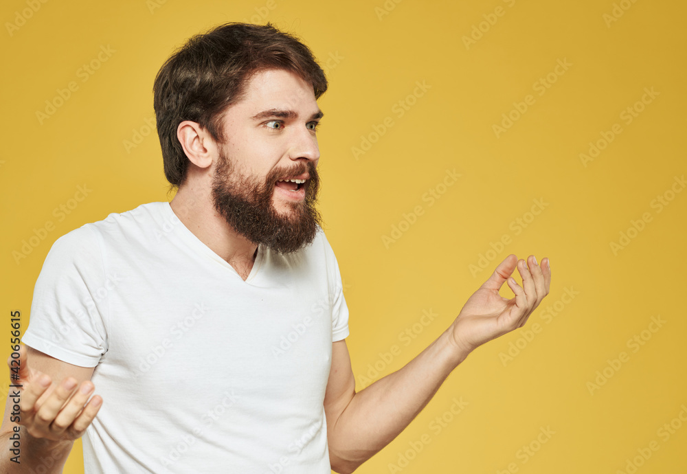 An energetic man on a yellow background gestures with his hands cropped view An energetic man on a yellow background gestures with his hands cropped view