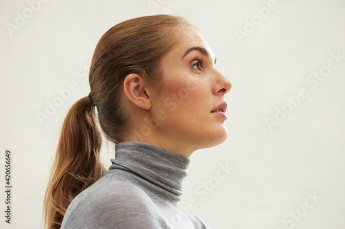 Young woman with a ponytail on gray photo