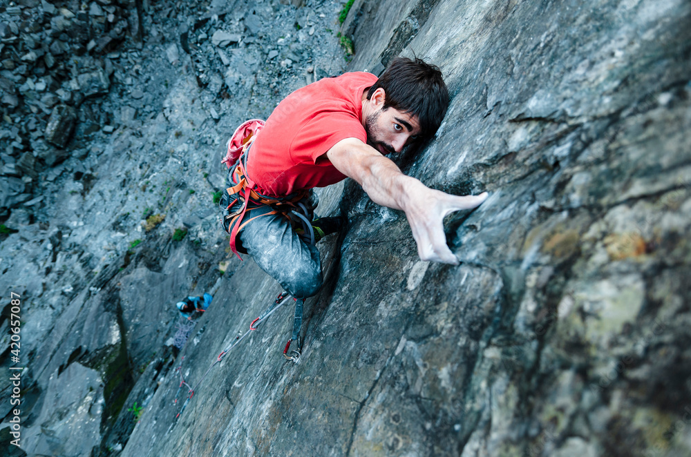 Climber grabbing a small ledge in quarry wall Climber grabbing a small ledge in quarry wall