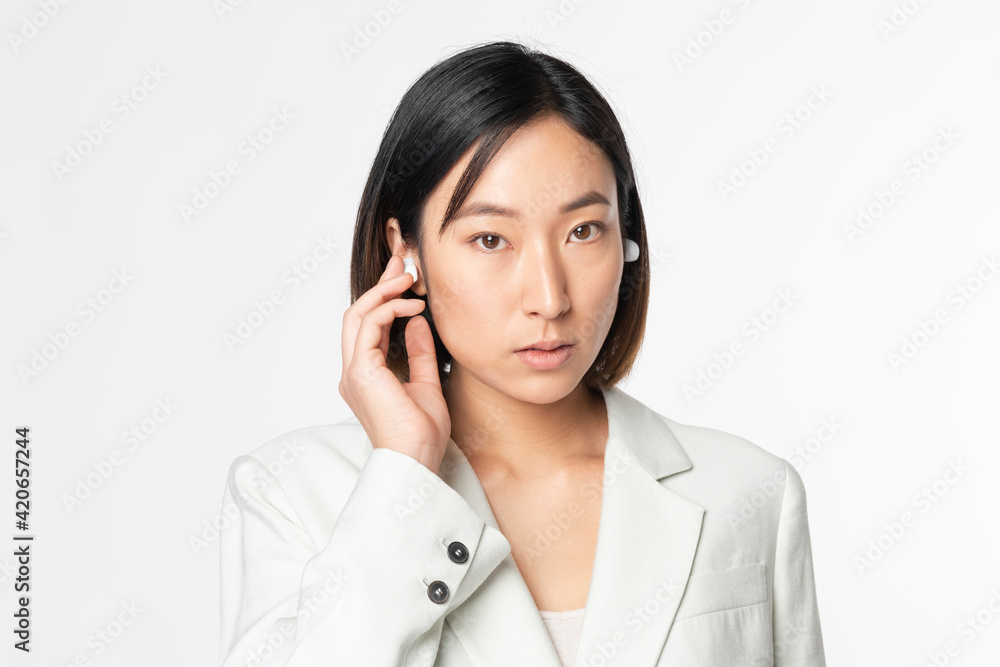Businesswoman with smart wireless earbuds futuristic communication Businesswoman with smart wireless earbuds futuristic communication