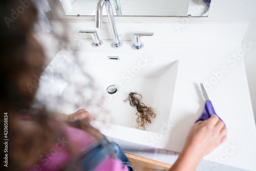 Bathroom vanity with clump of shorn curls and scissors
