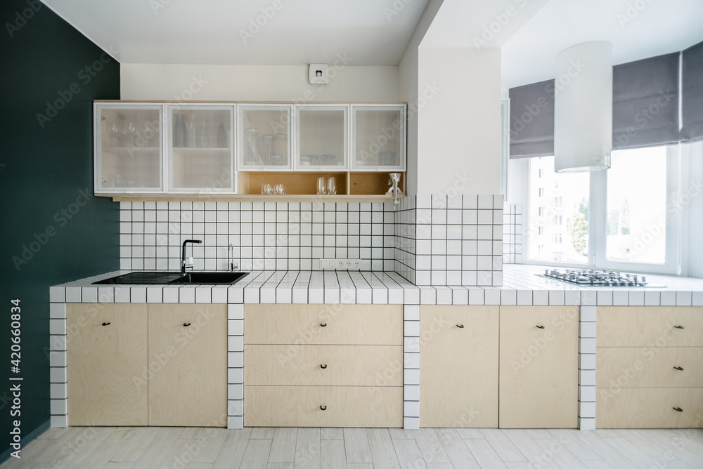 Kitchen in white tilles and a grey wall in a minimalist apartment Kitchen in white tilles and a grey wall in a minimalist apartment