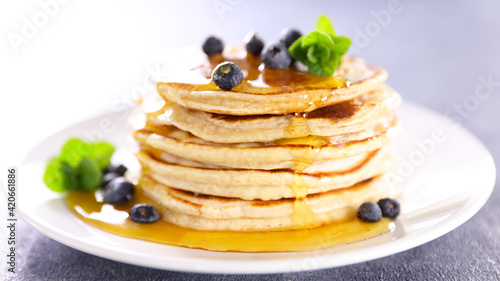 stack of pancake with pouring syrup