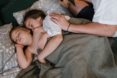 Cute sisters sleeping on bed together photo