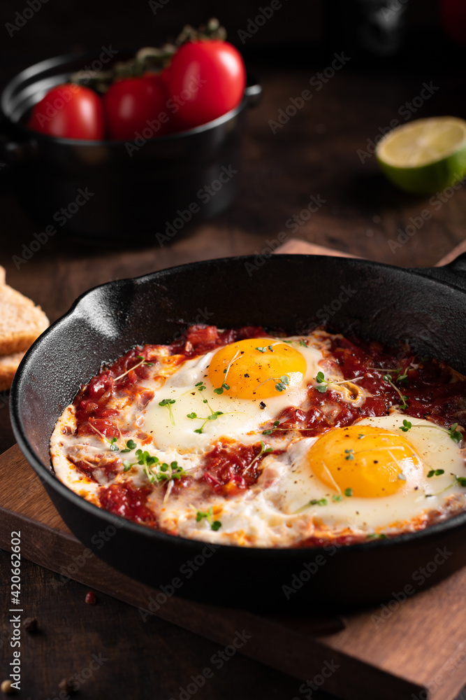 Israel traditional food shakshouka with micro greens in a cast-iron pan Israel traditional food shakshouka with micro greens in a cast-iron pan