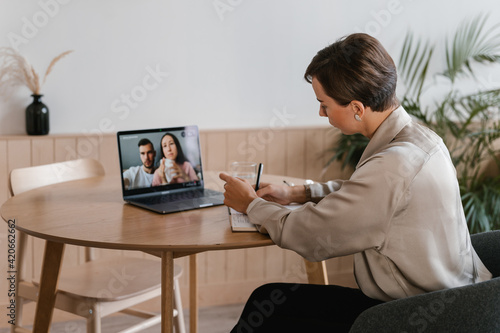 Female phycologist talking to couple on video chat via netbook photo