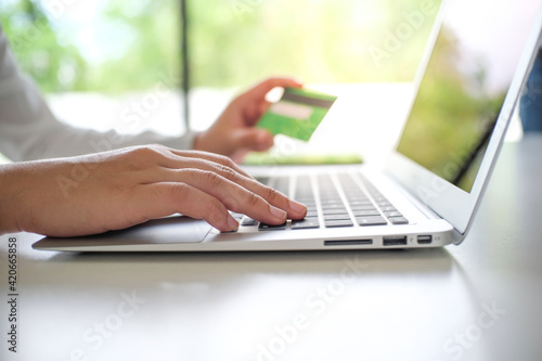 Woman shopping on laptop holding credit card for Internet online e-commerce shopping spending money Online shopping Mobile phone laptop concept