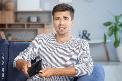Sad man with empty wallet a...