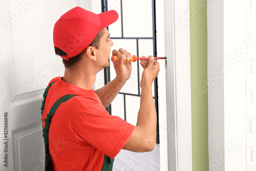 Worker repairing door lock ...