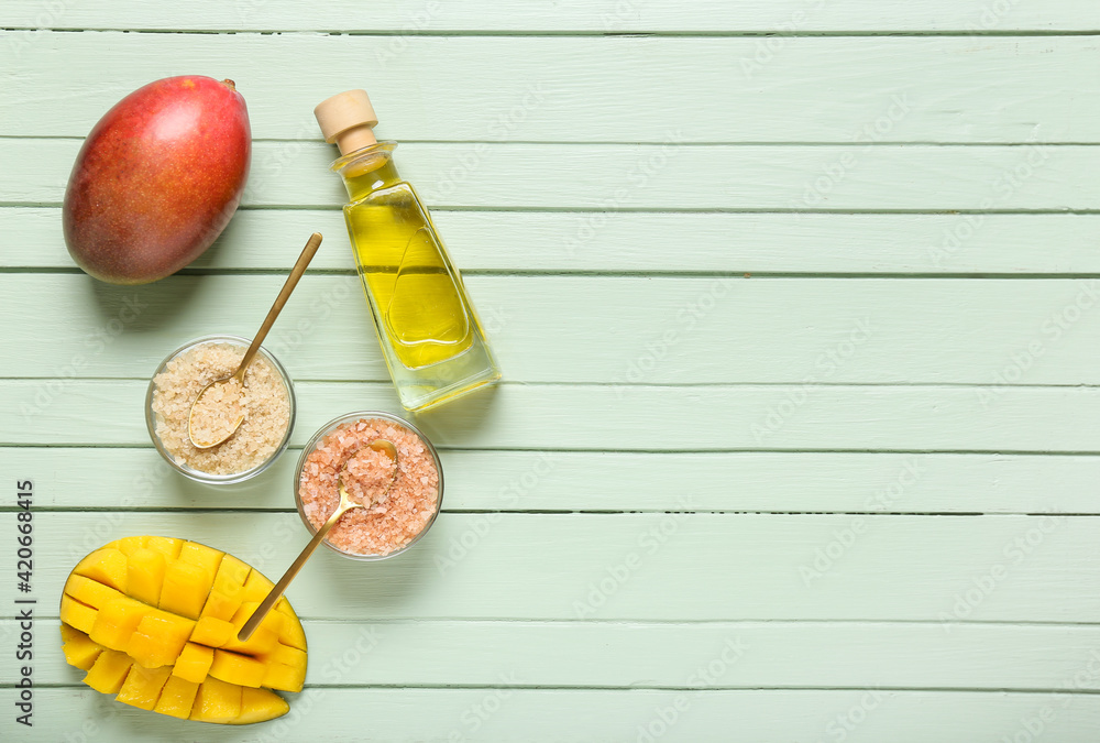 Bottle of mango essential oil and sea salt on color wooden background Bottle of mango essential oil and sea salt on color wooden background