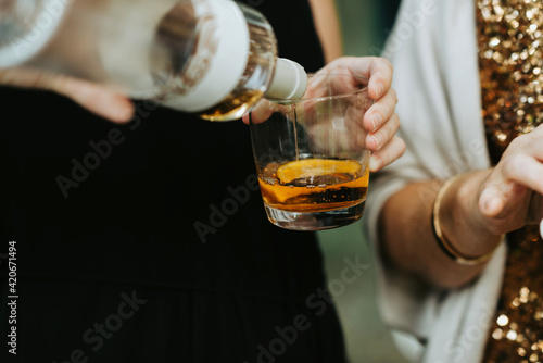 Pouring an alcoholic liquor drink with orange