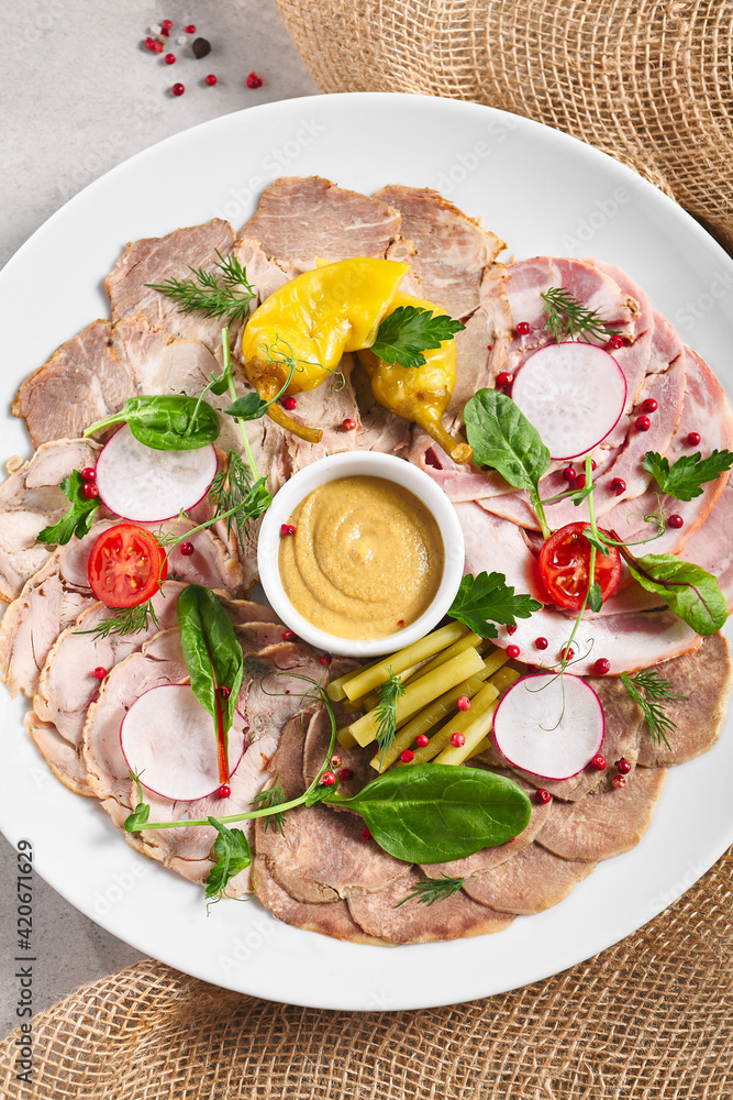 Cold Cut Meat Platter. Rustic style meat appetizers with dip and vegetables. Snack plate on grey table with sack napkin. Cold Cut Meat Platter. Rustic style meat appetizers with dip and vegetables. Snack plate on grey table with sack napkin.