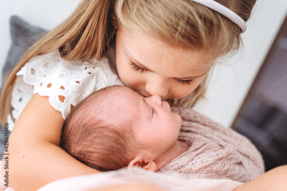 Young girl kissing her baby sister Young girl kissing her baby sister