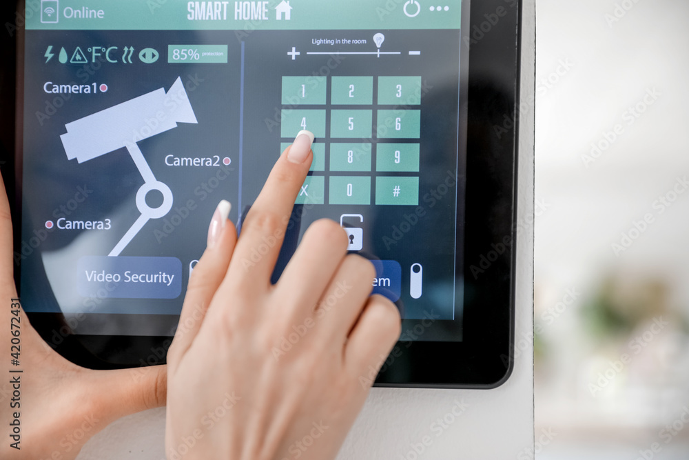 Woman using smart home security system control panel, closeup Woman using smart home security system control panel, closeup