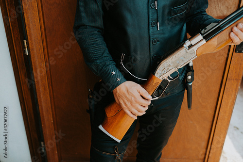 close up of a cowboy holding a big gun in his hands photo