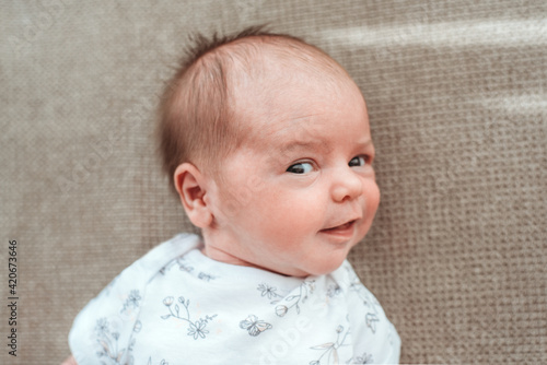 Beautiful newborn baby looking and smiling at the camera