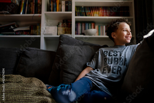 Smiling boy sits on couch photo