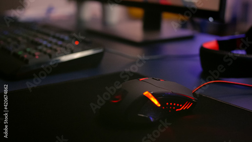 Closeup of professional mouse with RGB lighting during online shooter video games tournament. Home studio of esport video game player using powerful gaming PC