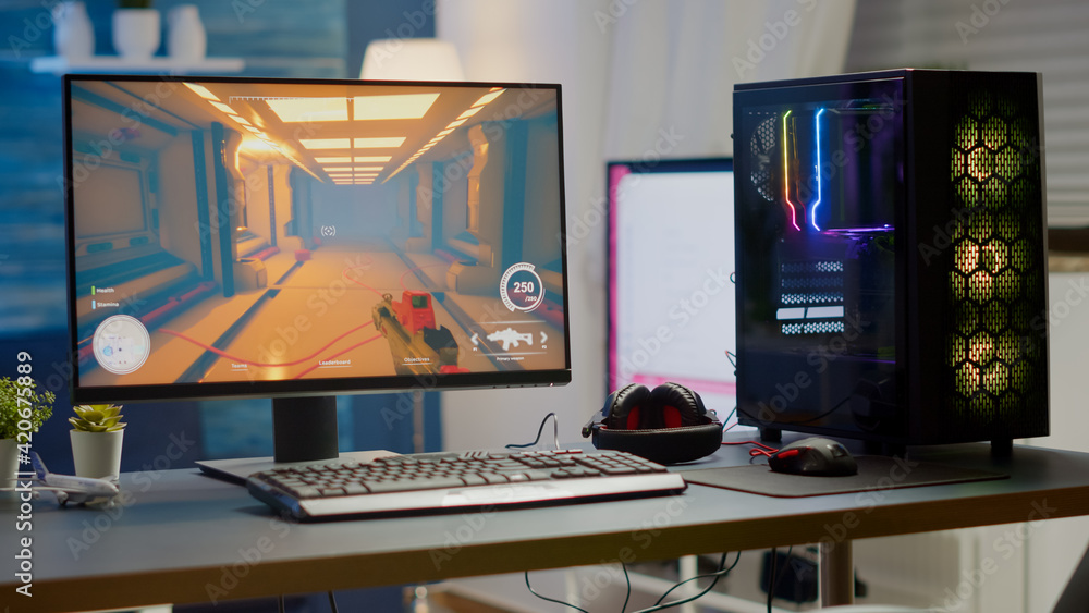 Naklejka premium Professsional gaming empty room studio with neon lights and RGB powerful computer, keyboard and mouse. FPS shooter video game on pc display, stream chat on television