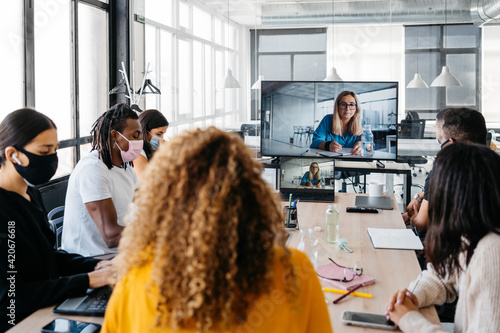 Multiehtnic group wearing face masks having a business virtual meeting photo