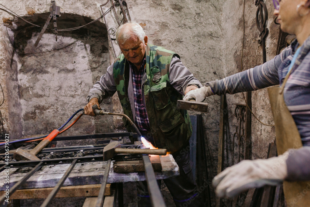 Father And Daughter, Co-Workers in Blacksmith Workshop Father And Daughter, Co-Workers in Blacksmith Workshop