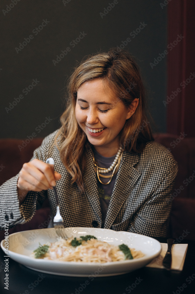 Smiling woman eating in cafe and having fun