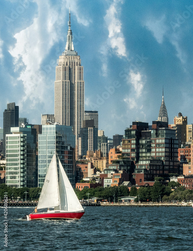 Sailing boat against a Manhattan skyline at sunny day.
