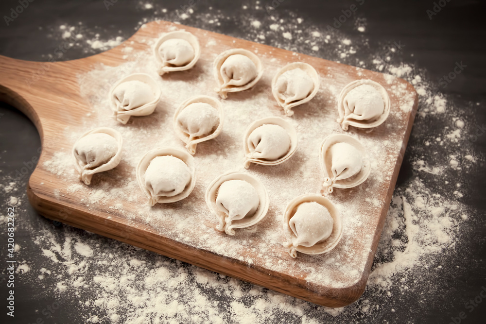 semi-finished pelmeni dumplings on the wooden board. semi-finished pelmeni dumplings on the wooden board.