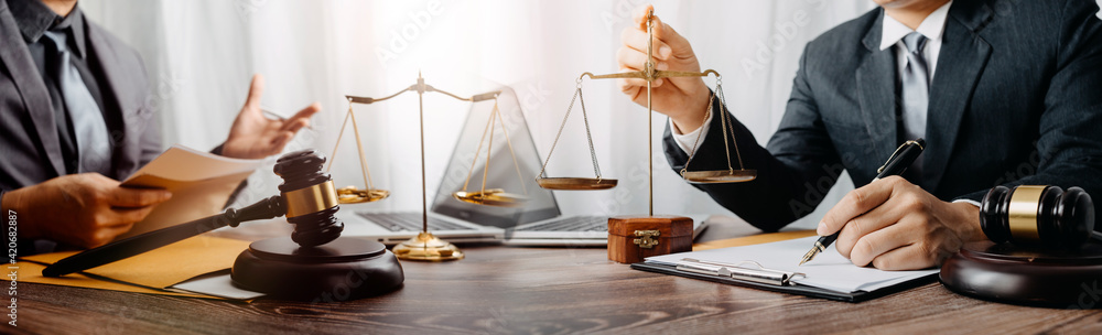 justice and law concept.Male judge in a courtroom on wooden table and Counselor or Male lawyer working in office. Legal law, advice and justice concept.