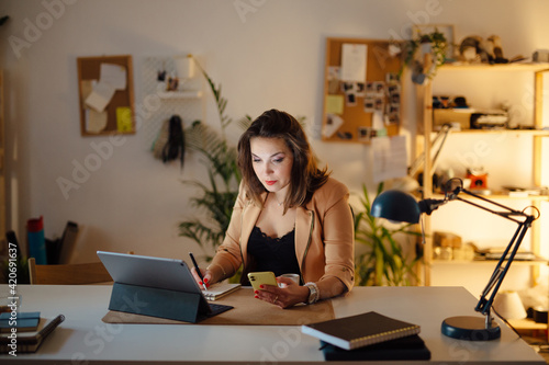 Woman using a phone in home office photo