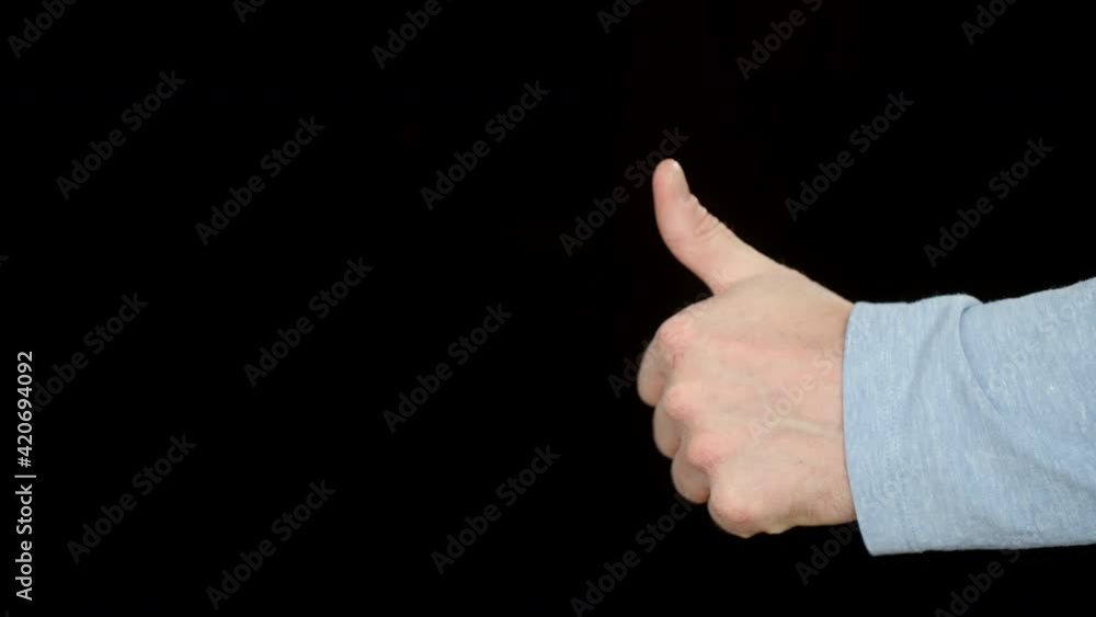 Close-up view of male hand showing thumb up on black background. Cropped shot of man showing thumb up gesture and approving something isolated on black Close-up view of male hand showing thumb up on black background. Cropped shot of man showing thumb up gesture and approving something isolated on black