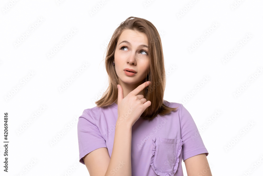 Thoughtful girl looking aside with hand on chin, wondering or asking a question Thoughtful girl looking aside with hand on chin, wondering or asking a question