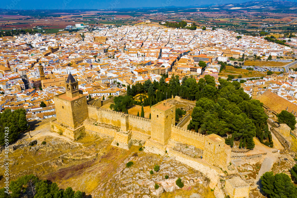 Aerial view of medieval Moorish castle of Alcazaba of Antequera on background with cityscape on sunny fall day, Malaga, Spain