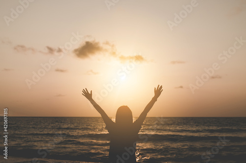 Woman rise hands up to sky travel around the world with summer beach freedom.