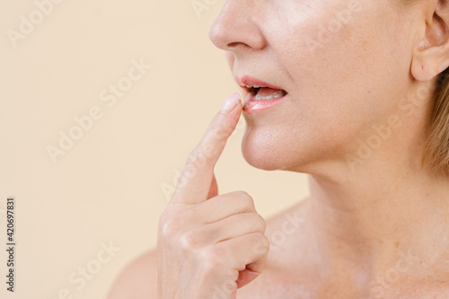 Crop woman applying lip balm in studio photo