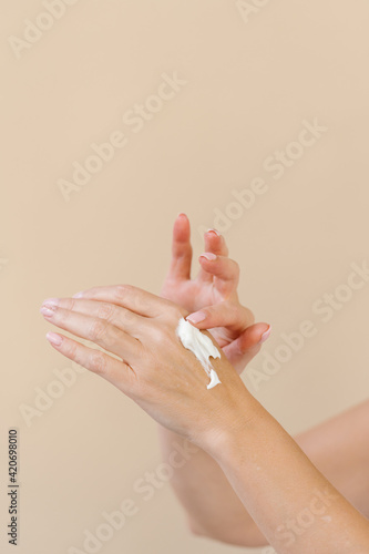 Crop woman applying daily hand cream photo