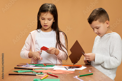 Fototapeta Naklejka Na Ścianę i Meble -  happy children cutting colored papers with scissors