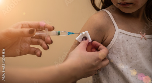 Doctor vaccinates child to stop coronavirus and other pandemic diseases. Concept fight against virus covid-19 corona virus. Syringe in a hand of a woman.