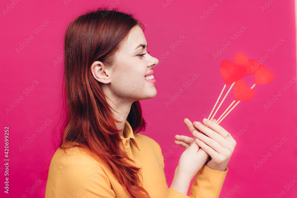 Fototapeta premium pretty woman in shirt holding heart on stick on pink background Copy Space