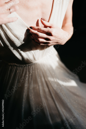 closeup of bride getting ready while sun hits her fragile skin photo